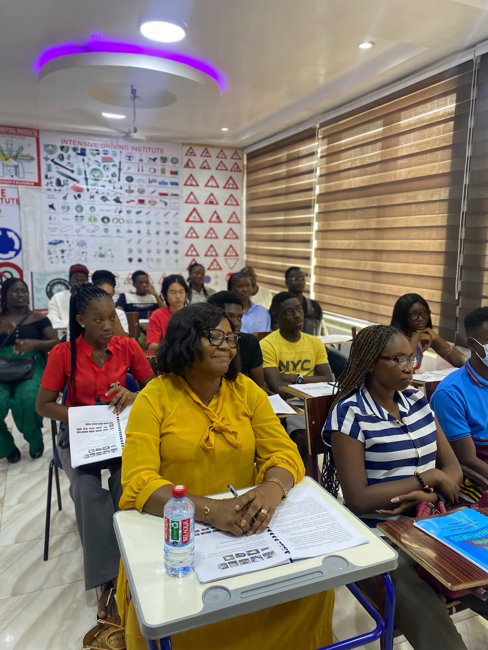Happy Ghanaian driving school students and graduates celebrating passing their driving test in Accra
