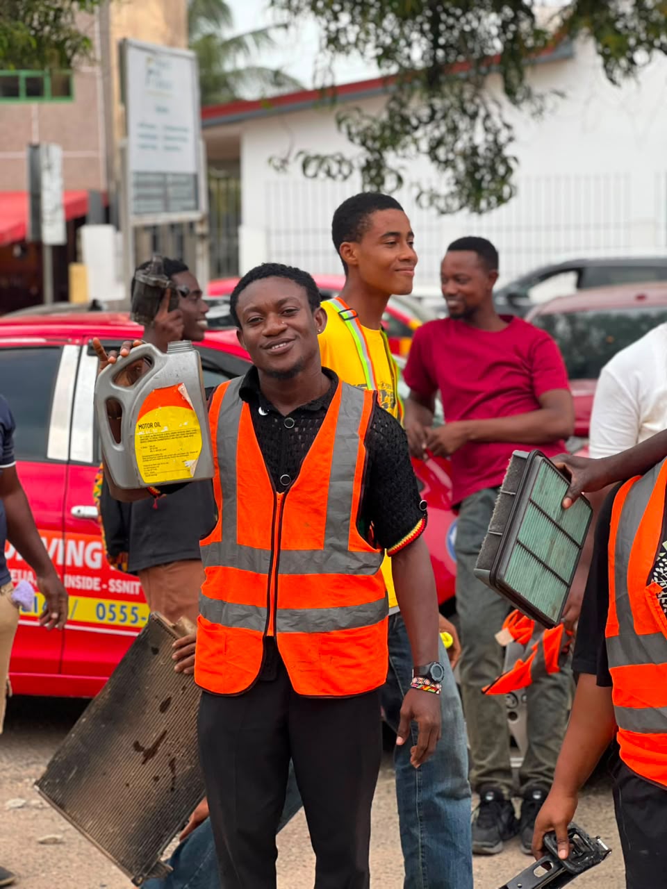 Students inspecting motor oil container and engine air filter