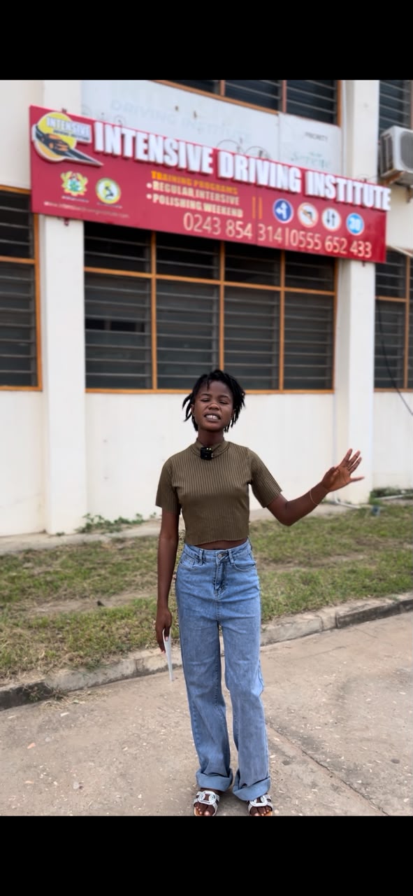 Student in front of Intensive Driving Institute building and programs signboard
